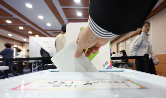 4·10 총선 사전투표 첫날인 5일 오전 서울 동작구 상도1동주민센터에서 유권자가 투표함에 용지를 넣고 있다. 연합뉴스